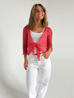 Modelfoto af pige som bærer en Arabella bluse i coral, samt et par hvide jeans. Alt fra By Sofie Sønderby
