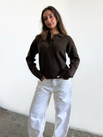 Modelfoto af pige i brun Catalina polo og hvide Nanna jeans. Alt er fra BySofieSønderby