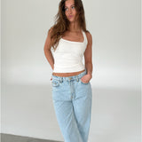 Modelfoto af pige med CHRISTINE top, hvid og NANNA jeans, lyseblå - begge fra fra BySofieSønderby