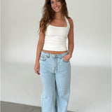 Modelfoto af pige med CHRISTINE top, hvid og NANNA jeans, lyseblå - begge fra fra BySofieSønderby