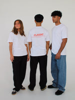 Tre personer iført hvide t-shirts står i hvidt rum. En person viser ryggen med teksten "CLASSIC" i rød på t-shirten. De andre ser forskellige retninger.