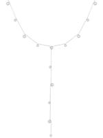 Halskæde med små kugler hænger elegant. Den er formet som et "Y" med kugler jævnt fordelt langs kæden. Baggrunden er lys, hvilket fremhæver det smykkende design.