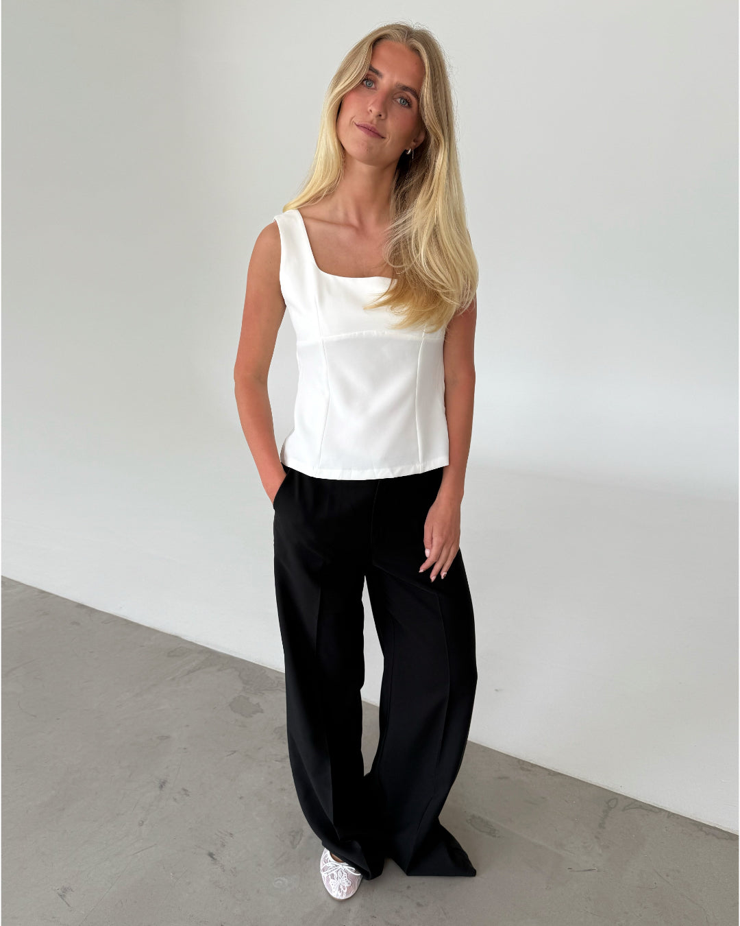 Modelfoto af pige med DOROTHY top, hvid og ELLIS bukser, sort - begge fra BySofieSønderby