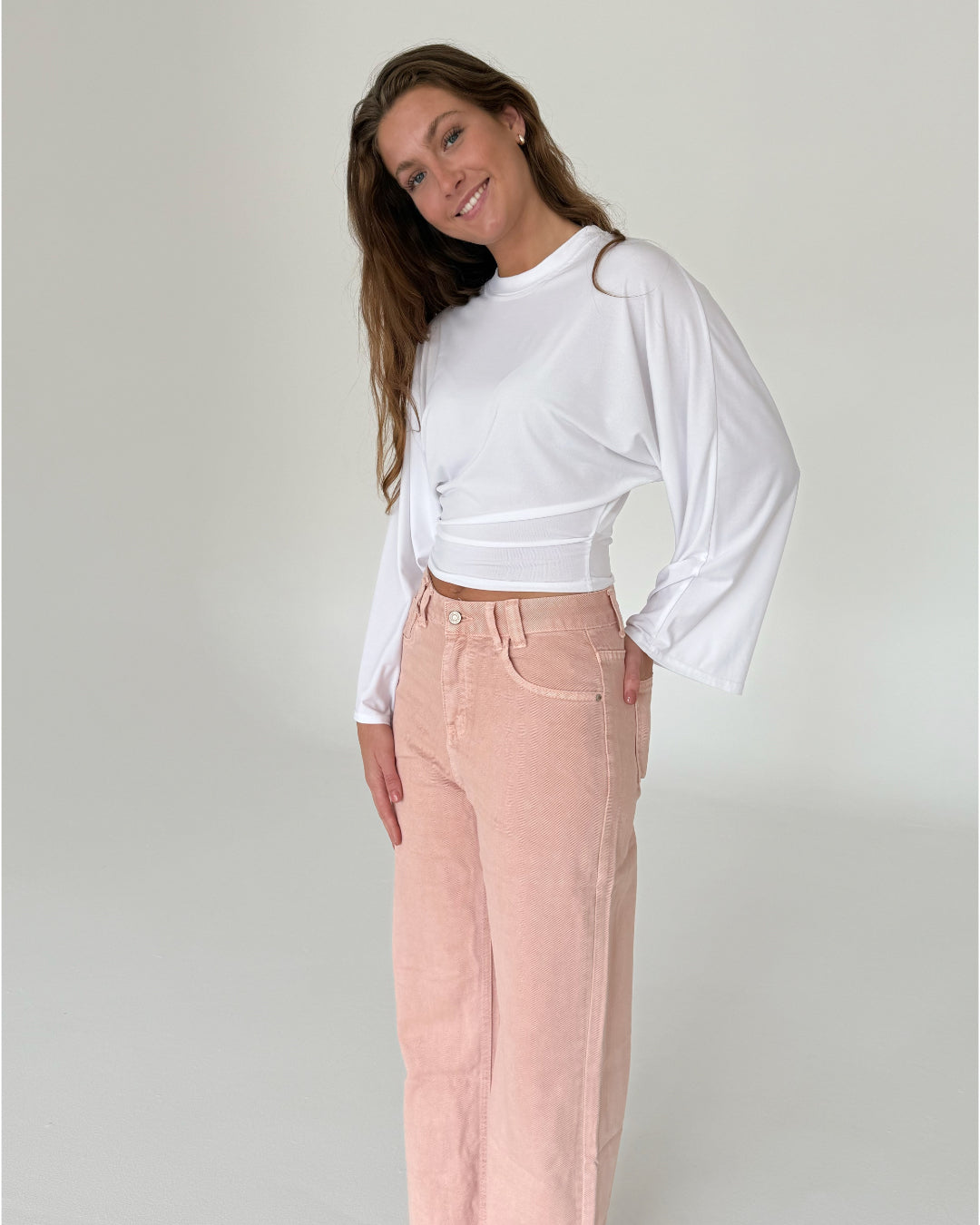 Modelfoto af pige med ESTHER waisted bluse, hvid og LORETTA jeans, lyserød - begge fra fra BySofieSønderby