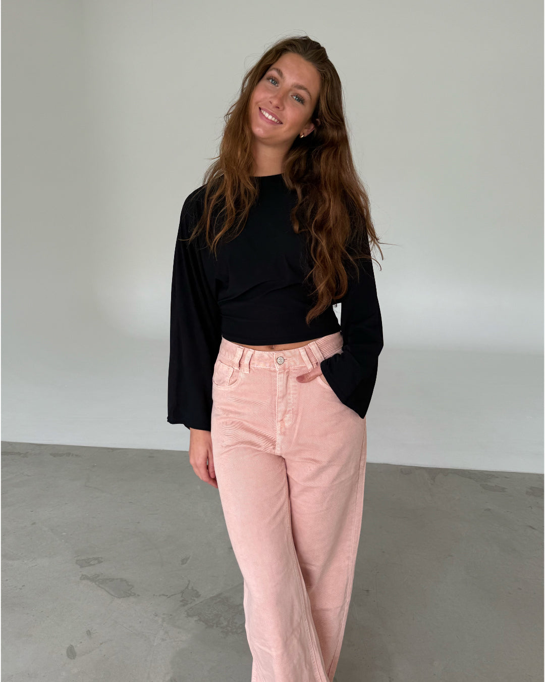 Modelfoto af pige med ESTHER waisted bluse, sort og LORETTA jeans, lyserød - begge fra fra BySofieSønderby