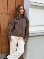 Modelfoto af pige i brun Lama læder jakke og beigefarvede Arianna jeans. Alt er fra BySofieSønderby