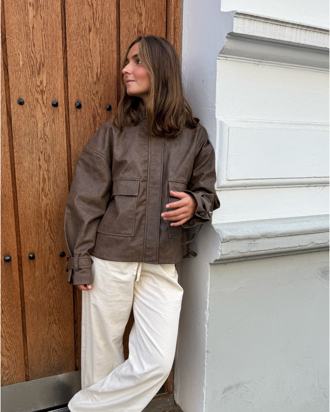 Modelfoto af pige i brun Lama læder jakke og beigefarvede Arianna jeans. Alt er fra BySofieSønderby
