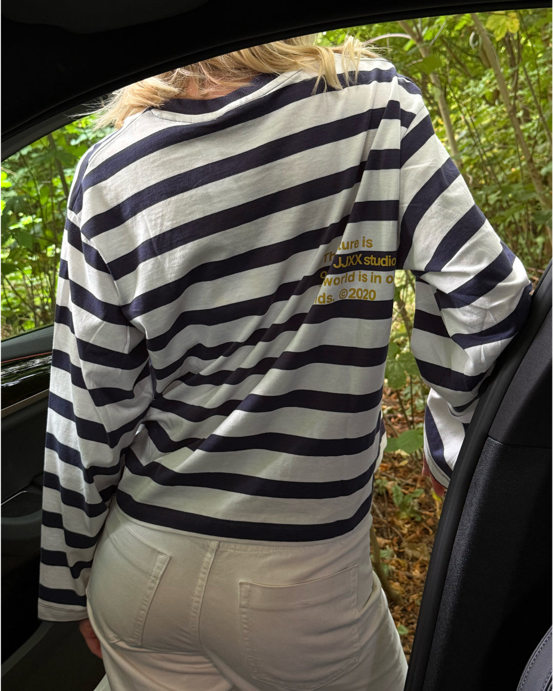 Modelfoto af pige i Lona bluse i farven hvid med navy striber og hvide Nanna jeans. Fra BySofieSønderby