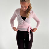 Modelfoto af pige i lyserød Luna wrap bluse og brune Sania bukser. Fra BySofieSønderby