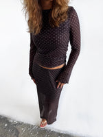 Modelfoto af pige i Minna nederdel og Minna bluse. Begge dele i farven brun med hvide prikker. Alt er fra BySofieSønderby