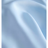 Blått stof, der ligger i bløde folder, skaber en rolig og elegant atmosfære.