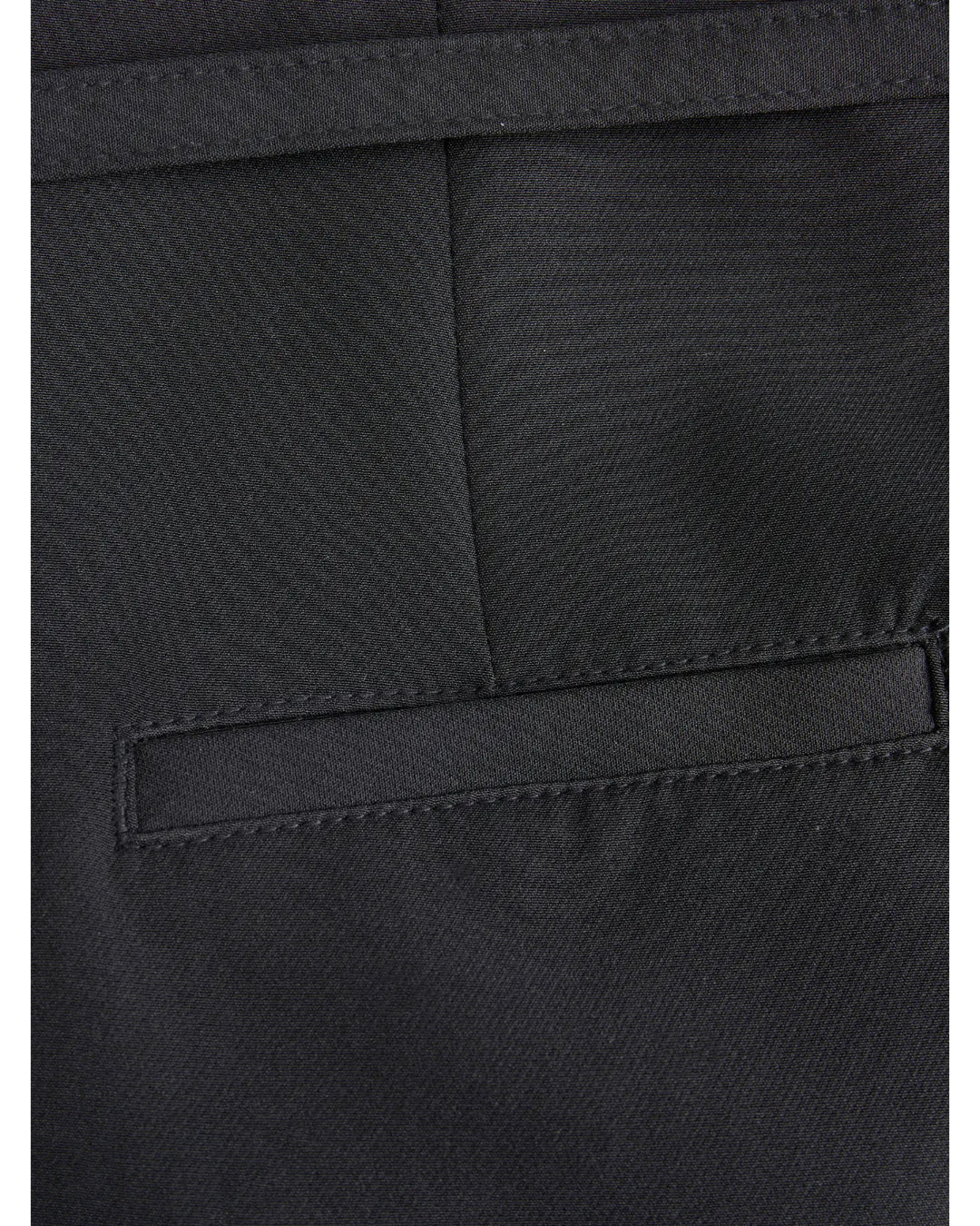 Lomme af sort stof, syet ind i et par bukser, med en skrå åbning. Stoffet er jævnt vævet, og sømmene er præcise, hvilket giver et elegant udseende.
