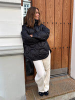 Modelfoto af pige i sort Stella jakke og beigefarvede Arianna jeans. Alt er fra BySofieSønderby