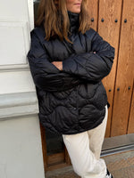 Modelfoto af pige i sort Stella jakke og beigefarvede Arianna jeans. Alt er fra BySofieSønderby