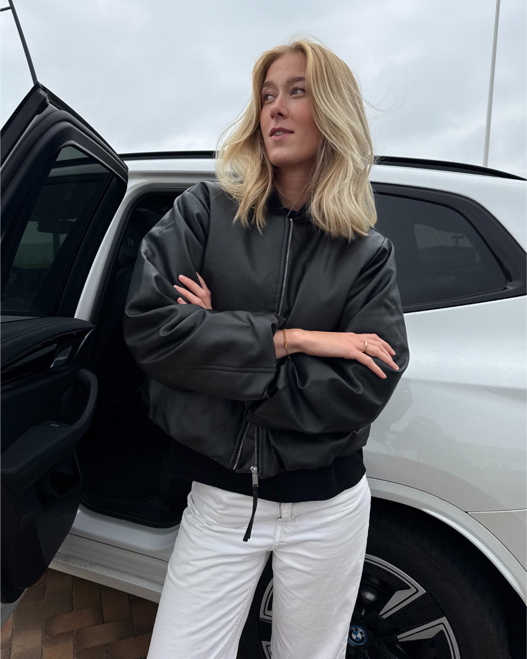 Modelfoto af pige der bærer Trudea jakke i sort, derudover har hun hvide Nanna jeans på. Alt fra BySofieSønderby
