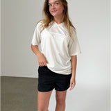 Modelfoto af pige iklædt ZOLA t-shirt, hvid og LANA shorts, sort - begge fra BySofieSønderby