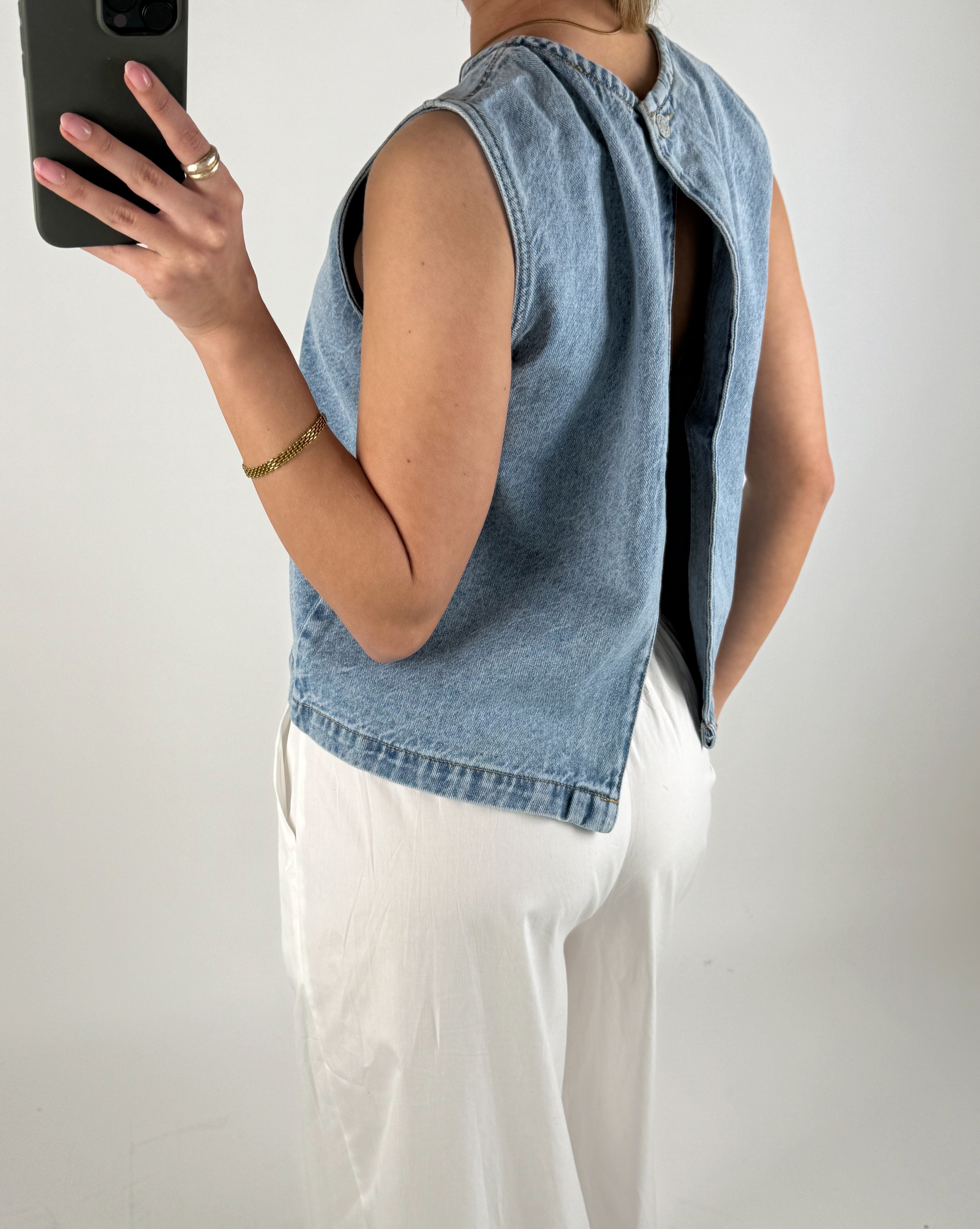Modelbillede af pige der bærer en blå DORA denim top. Set bagfra. Fra BySofieSønderby