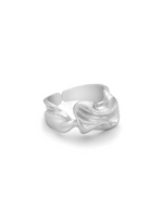 En sølvfarvet ring ligger på en hvid baggrund. Ringen har en organisk, skulpturel form, der ligner smeltet metal.