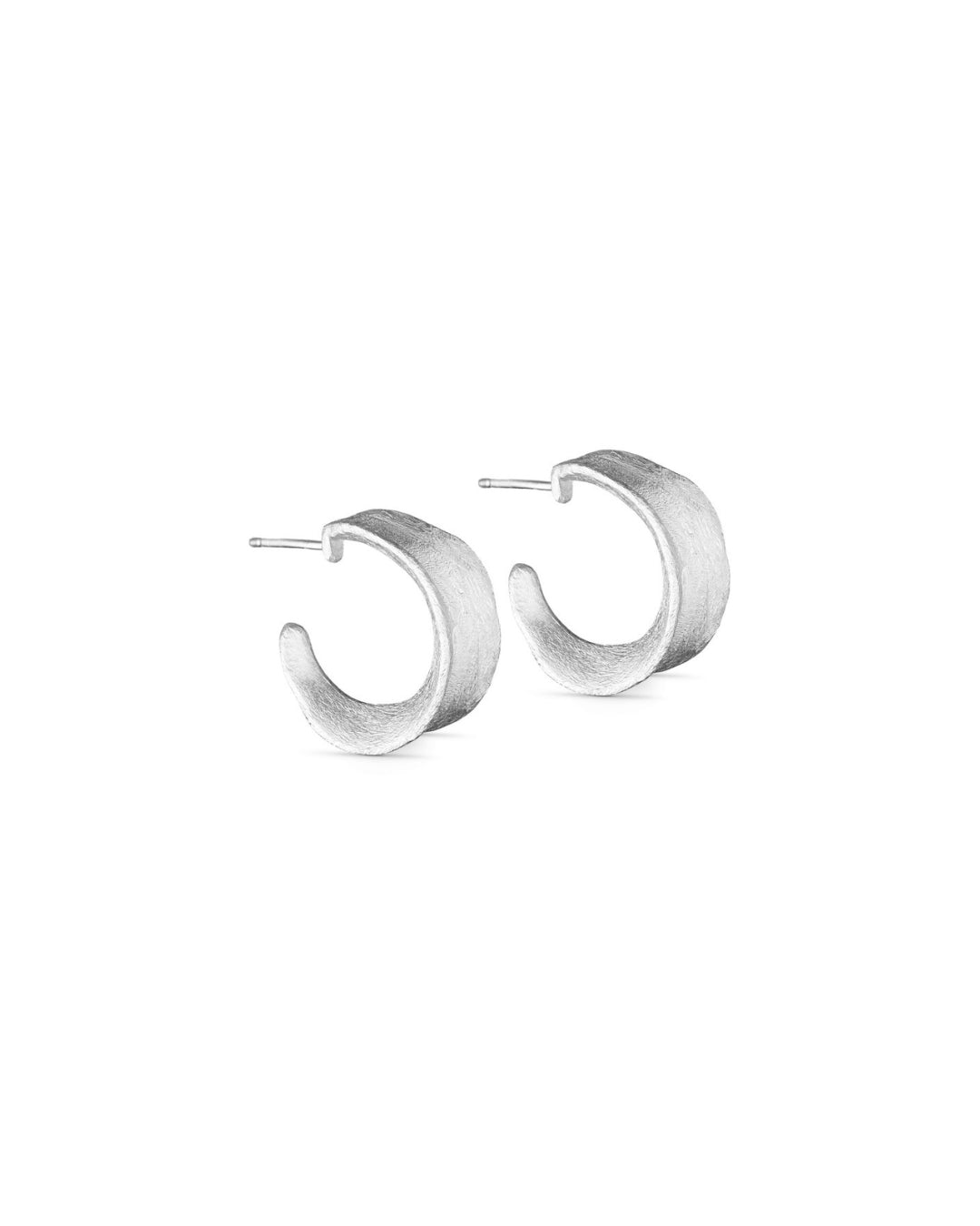 To sølvfarvede, halvmåneformede øreringe hviler på en hvid baggrund, fremvisende deres minimalistiske design og diskrete elegance.