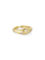 En gylden ring, prydet med tre små diamanter, ligger på en hvid baggrund. Ringen har en åben ende og en mat, tekstureret overflade.