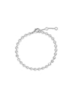 Et sølvfarvet armbånd ligger i en cirkel på en hvid baggrund. Armbåndet har små, cirkulære charms med stråleformede udskæringer.