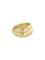 En guldring ligger isoleret på en hvid baggrund. Ringen har en bred, skulpturel form med en rille, der deler den i to sektioner.