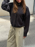 Stemningsbillede af pige der bærer beige KYOTO jorts og sort RHEA jakke.  Fra BySofieSønderby