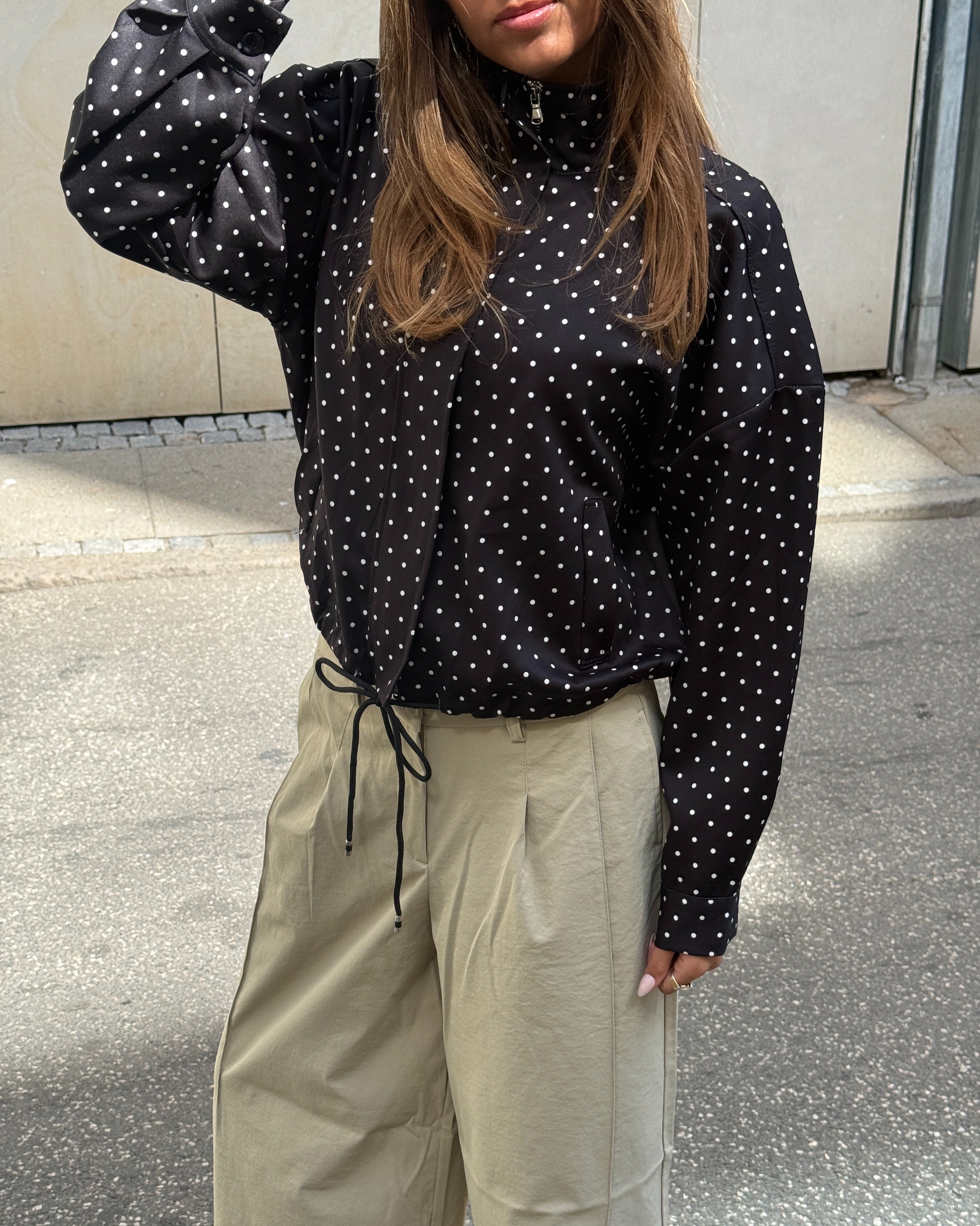 Stemningsbillede af pige der bærer beige KYOTO jorts og sort RHEA jakke.  Fra BySofieSønderby
