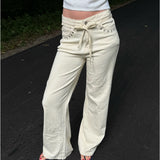 Modelfoto af pige i cremefarvede Adrianna jeans og hvid top. Alt er fra BySofieSønderby