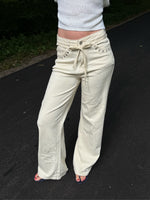 Modelfoto af pige i cremefarvede Adrianna jeans og hvid top. Alt er fra BySofieSønderby