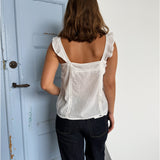 Modelfoto af pige som bærer en Amona top i hvid, samt et par mørkeblå jeans. Alt fra By Sofie Sønderby