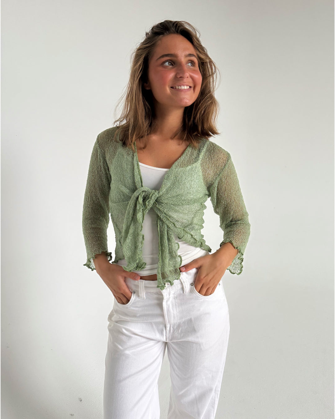 Modelfoto af pige som bærer en Arabella bluse i grøn, samt et par hvide jeans. Alt fra By Sofie Sønderby