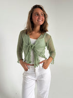 Modelfoto af pige som bærer en Arabella bluse i grøn, samt et par hvide jeans. Alt fra By Sofie Sønderby