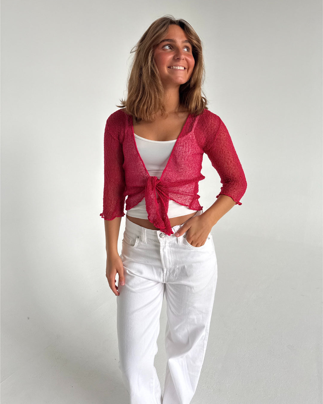 Modelfoto af pige som bærer en Arabella bluse i rød, samt et par hvide jeans. Alt fra By Sofie Sønderby