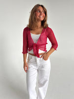 Modelfoto af pige som bærer en Arabella bluse i rød, samt et par hvide jeans. Alt fra By Sofie Sønderby