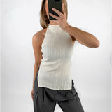 Modelfoto af pige med cremefarvet ASHLYN halterneck top, samt grå MILAN bukser. Set forfra. Alt er fra BySofieSønderby