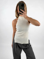 Modelfoto af pige med cremefarvet ASHLYN halterneck top, samt grå MILAN bukser. Set forfra. Alt er fra BySofieSønderby