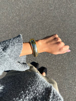 Modelfoto af en Avani guld armbånd. Baggrund er grå. Fra BySofieSønderby
