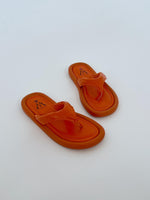 Orange sandaler ligger stille på en hvid baggrund. Sandalerne har en logoindgravering "M CINV 36".