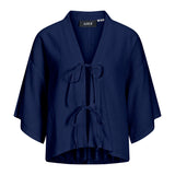 Mørkeblå kortærmet kimono med bindebånd foran. Påsyet mærke med teksten "JJXX" ved halsen. Baggrunden er hvid, hvilket fremhæver kimonoens farve og detalje.