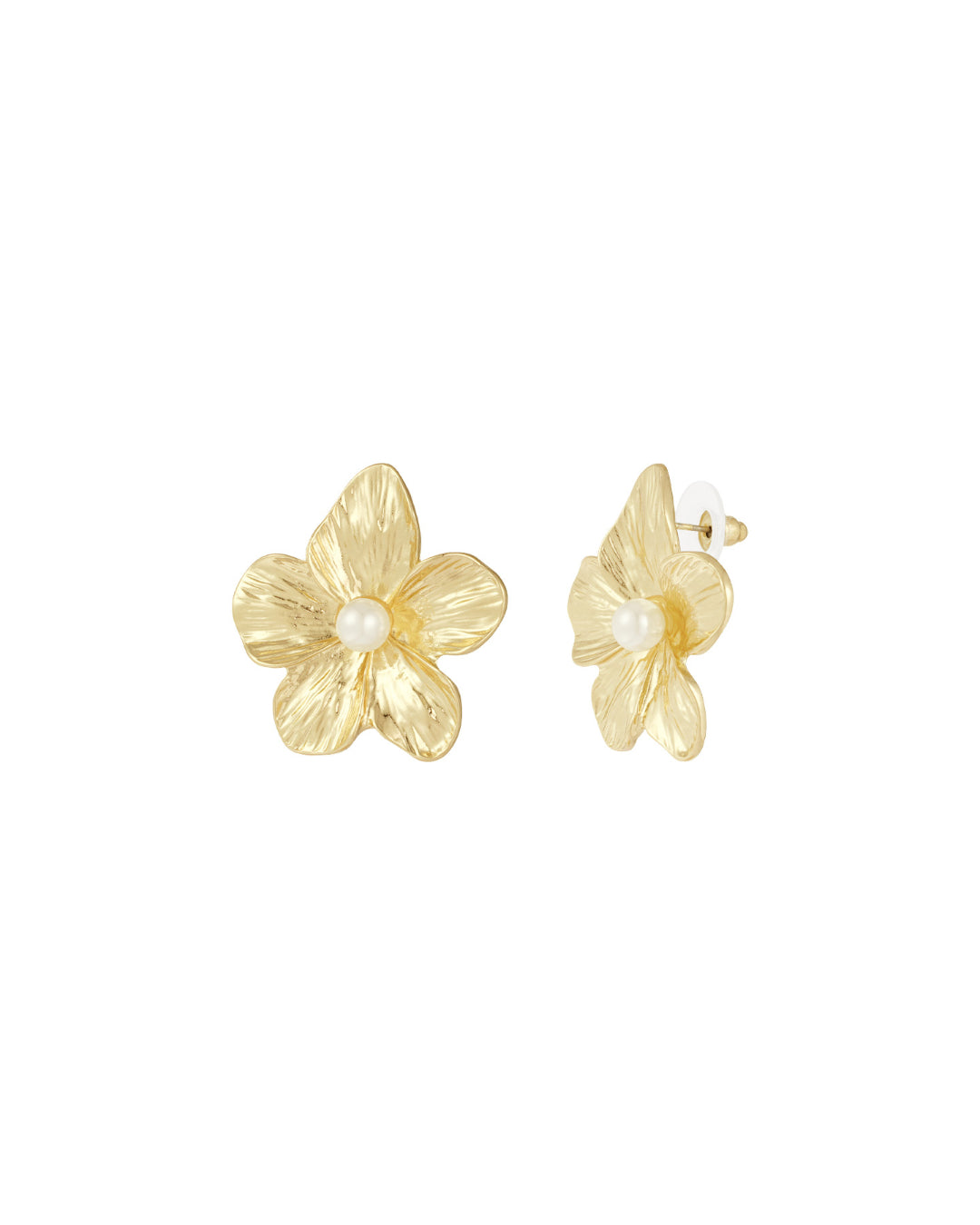 To blomsterformede øreringe i guld med en perle i midten ligger side om side på en hvid baggrund.