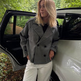 Modelfoto af pige i en grå Carlie jakke og hvide Nanna jeans. Alt er fra BySofieSønderby