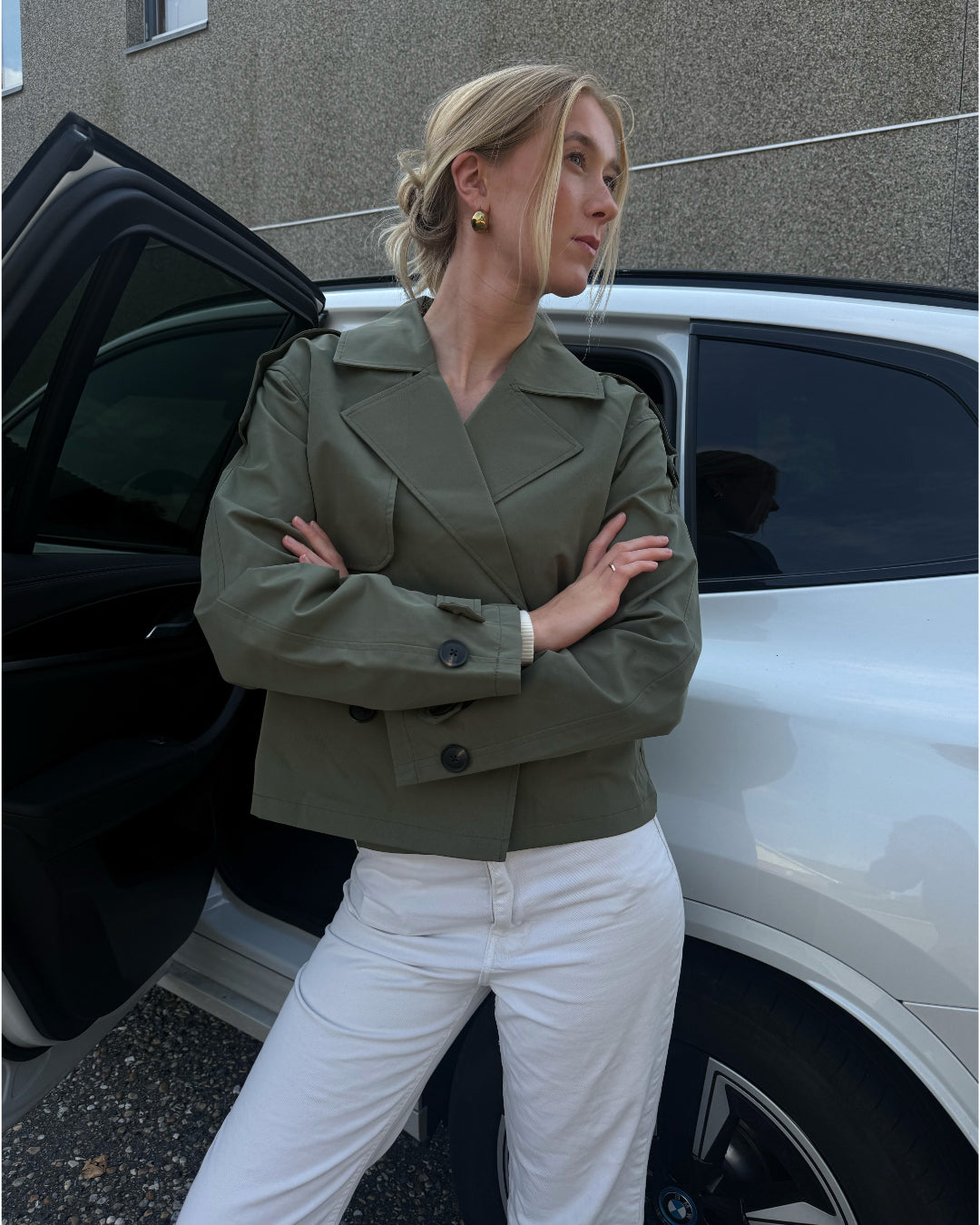 Modelfoto af pige der bærer Carlie jakke i kaki, samt hvid bukser. Alt fra BySofieSønderby