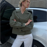 Modelfoto af pige der bærer Carlie jakke i kaki, samt hvid bukser. Alt fra BySofieSønderby