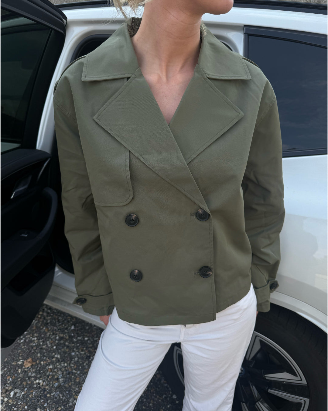 Modelfoto af pige der bærer Carlie jakke i kaki, samt hvid bukser. Alt fra BySofieSønderby