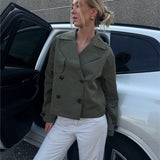 Modelfoto af pige der bærer Carlie jakke i kaki, samt hvid bukser. Alt fra BySofieSønderby