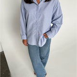 Modelfoto af pige der bærer en lyseblå stribet Caro skjorte, samt blå Nanna jeans. Alt fra BySofieSønderby