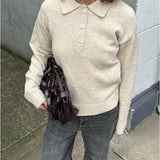 Modelfoto af pige i brun Catalina strik polo, samt grå Nanna jeans. Alt er fra BySofieSønderby