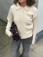 Modelfoto af pige i brun Catalina strik polo, samt grå Nanna jeans. Alt er fra BySofieSønderby