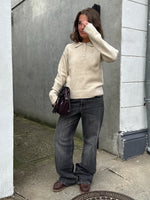 Modelfoto af pige i beige Catalina strik polo, samt grå Nanna jeans. Alt er fra BySofieSønderby